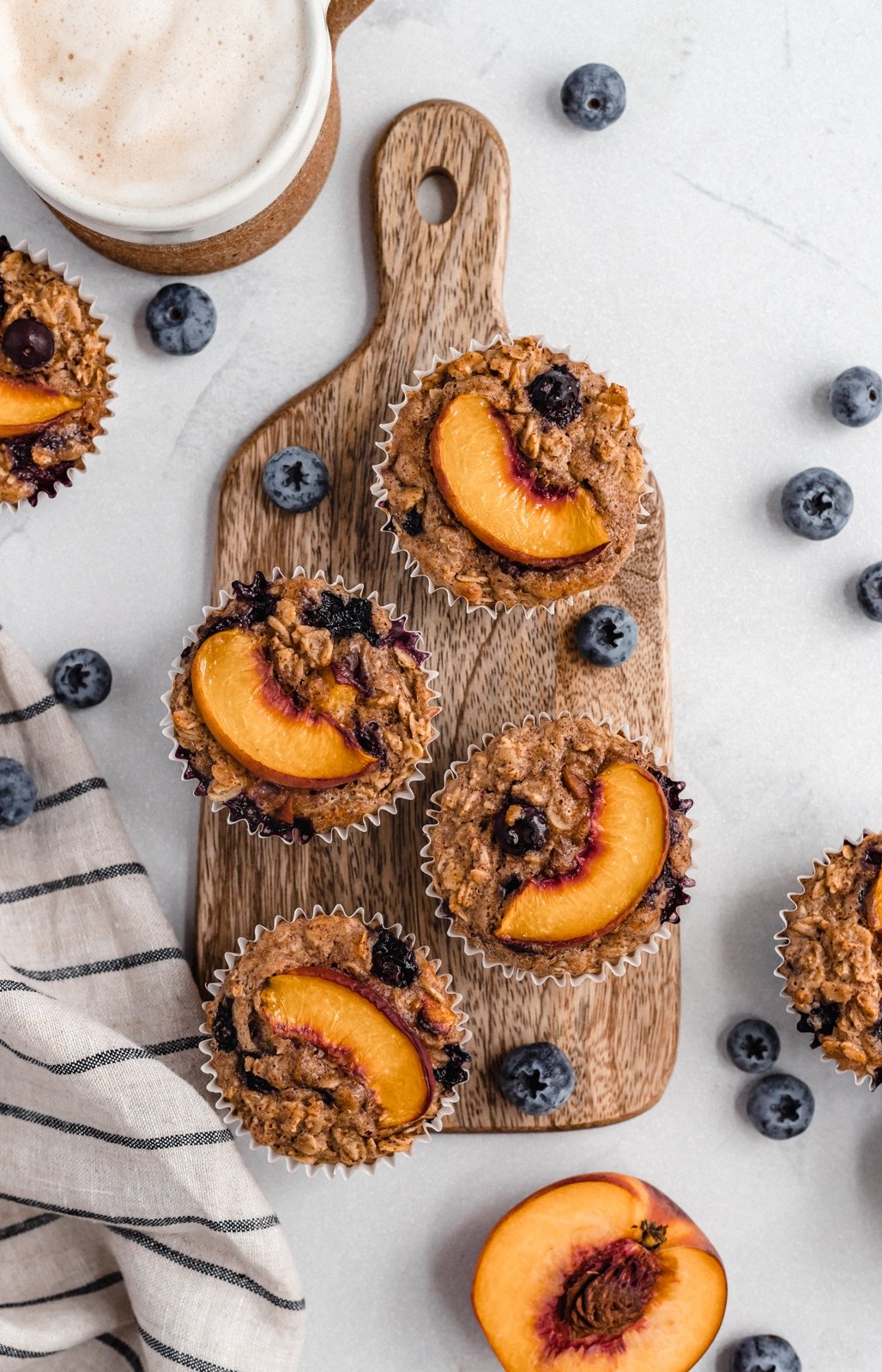 almond butter peach blueberry baked oatmeal cups on a wooden board