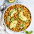 arroz con gandules in a bowl topped with sliced avocado