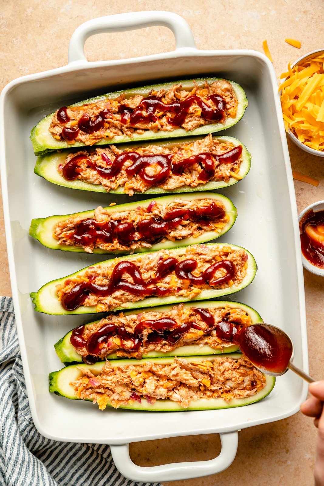 topping bbq chicken zucchini boats with extra bbq sauce