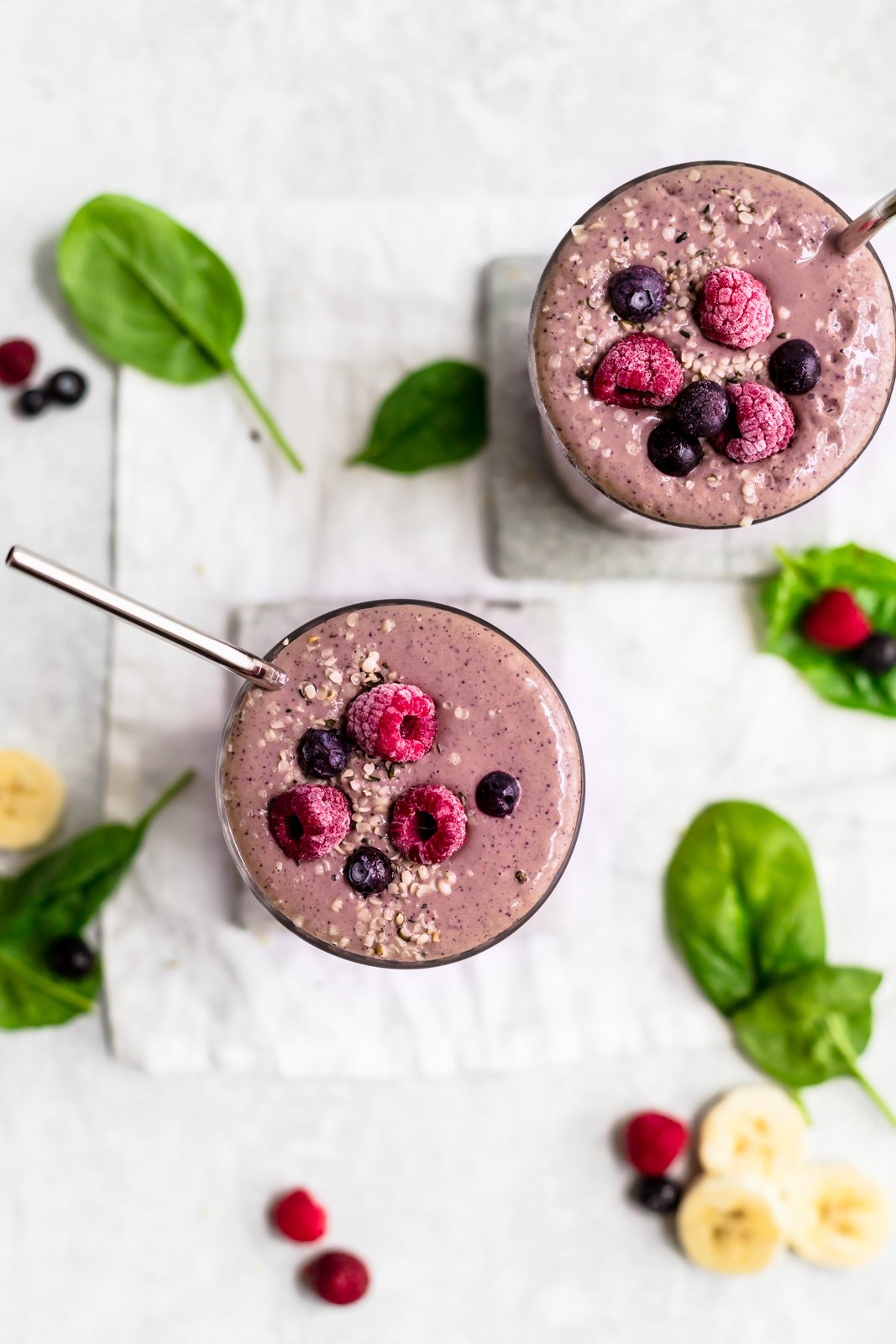 two mixed berry smoothies topped with extra berries
