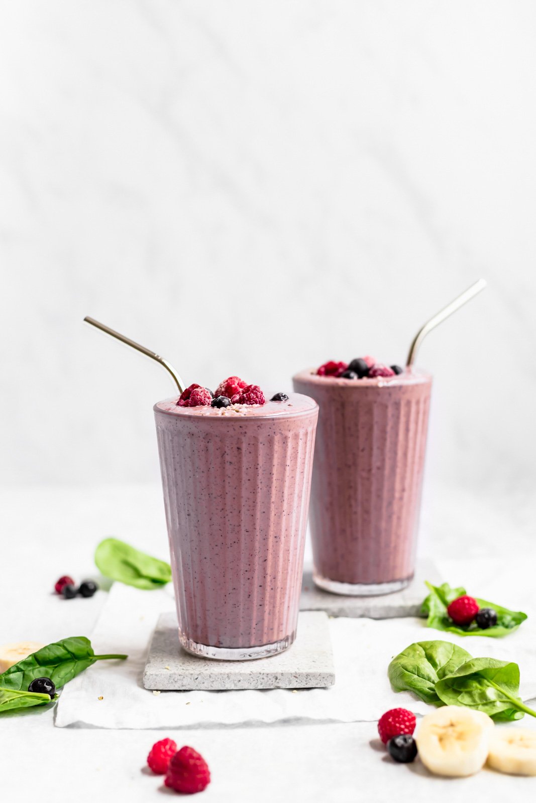two berry smoothies with berries on top