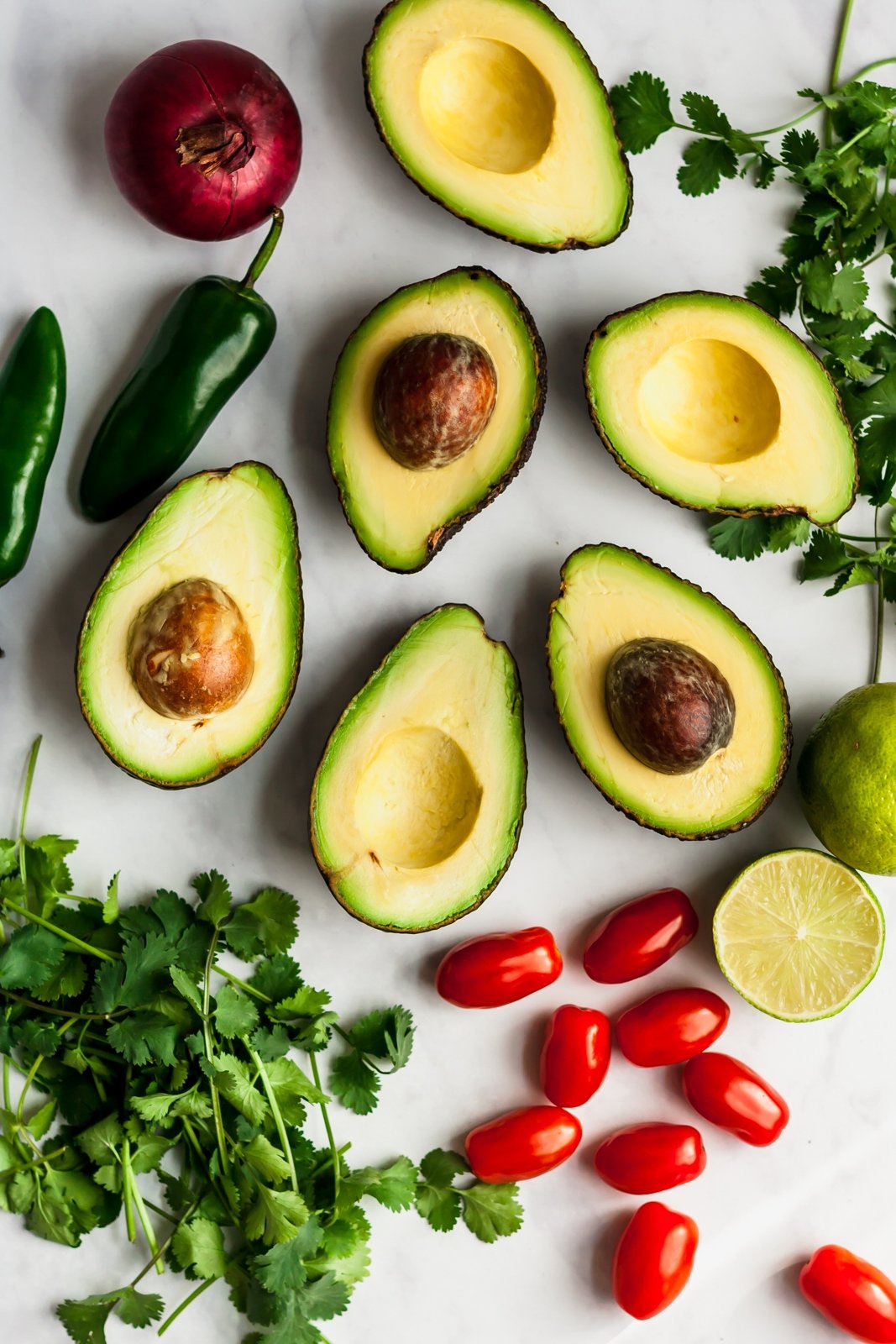 ingredients for the best guacamole on a grey board