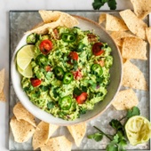 the best guacamole in a bowl next to tortilla chips