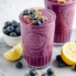 lemon blueberry smoothie in a glass topped with blueberries