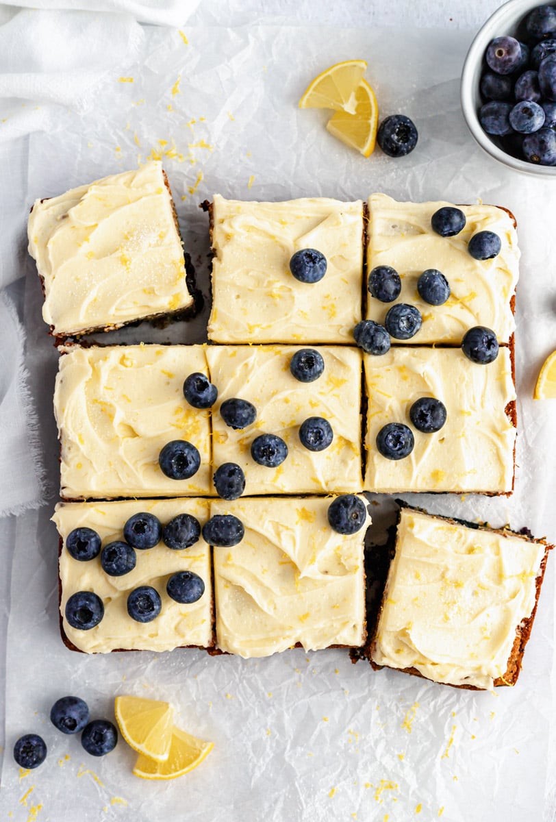 lemon blueberry zucchini cake topped with lemon frosting and blueberries