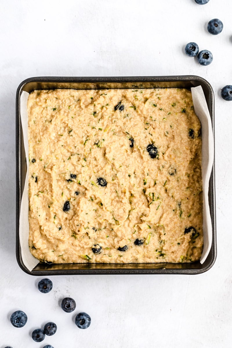 unbaked gluten free lemon blueberry zucchini cake in a square pan