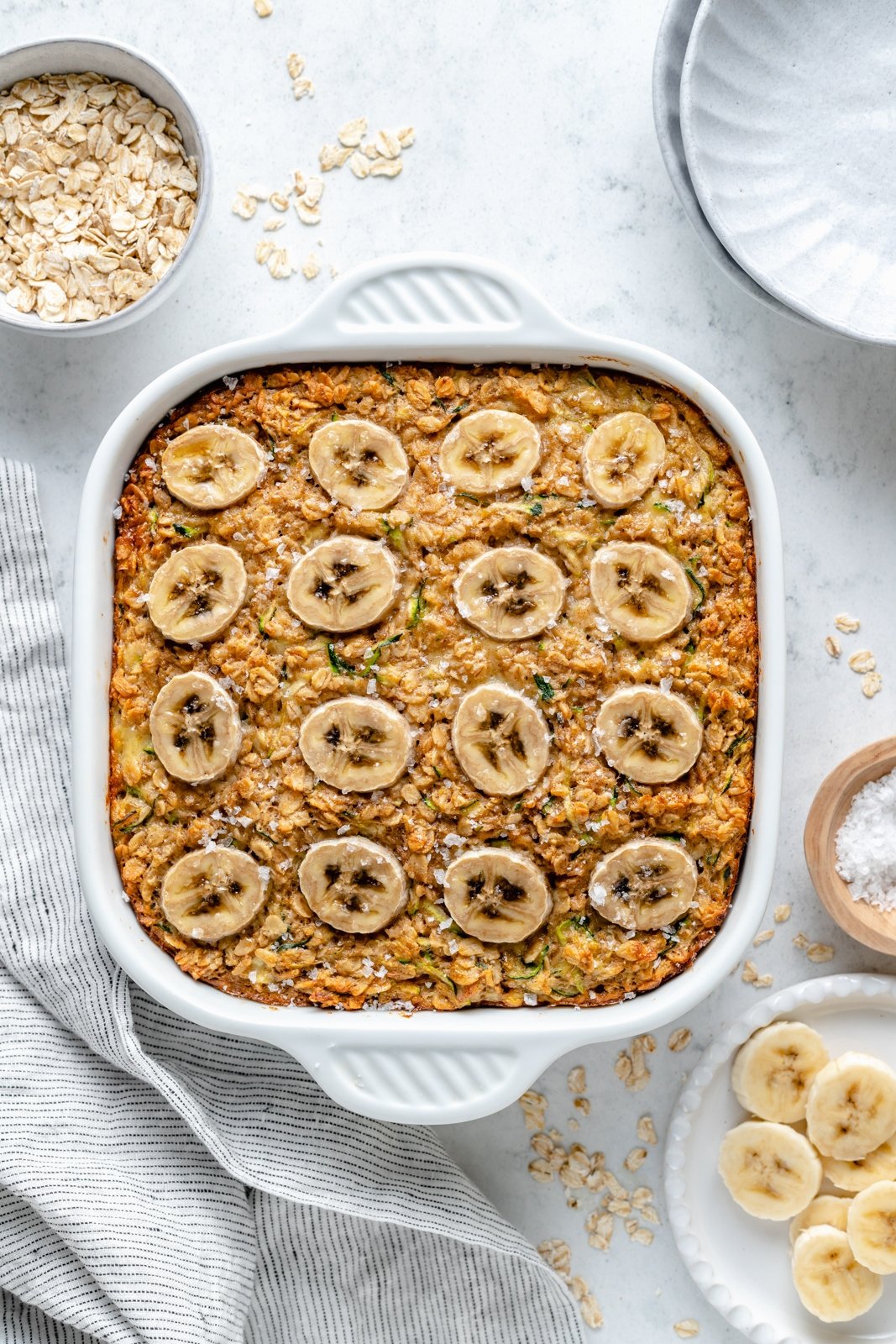 banana zucchini baked oatmeal in a pan topped with banana slices