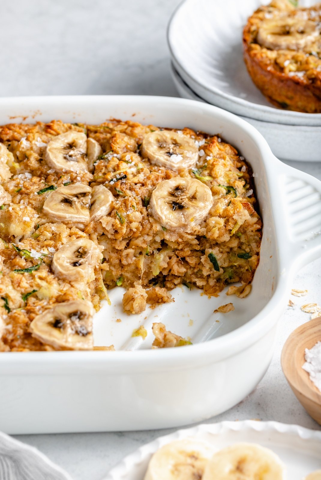 gluten free zucchini banana baked oatmeal in a pan with a sliced cut out