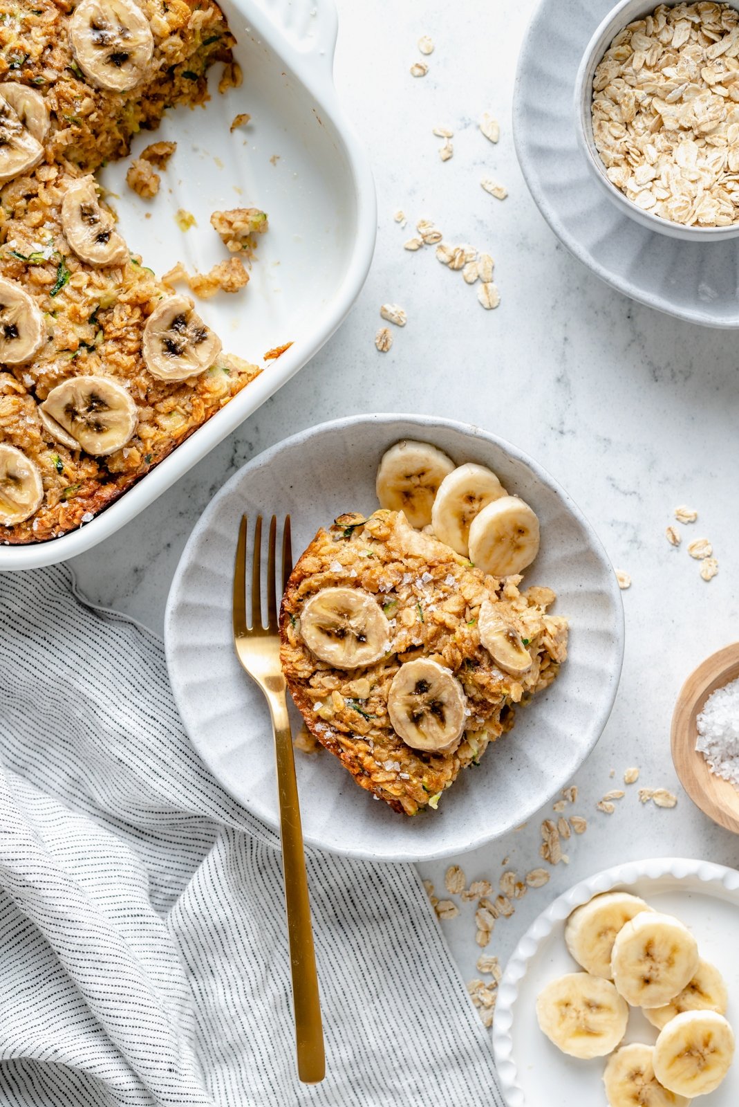 healthy banana zucchini baked oatmeal on a plate next to the full dish