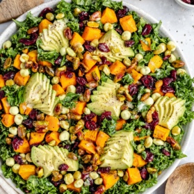 sweet potato kale salad in a bowl topped with avocado