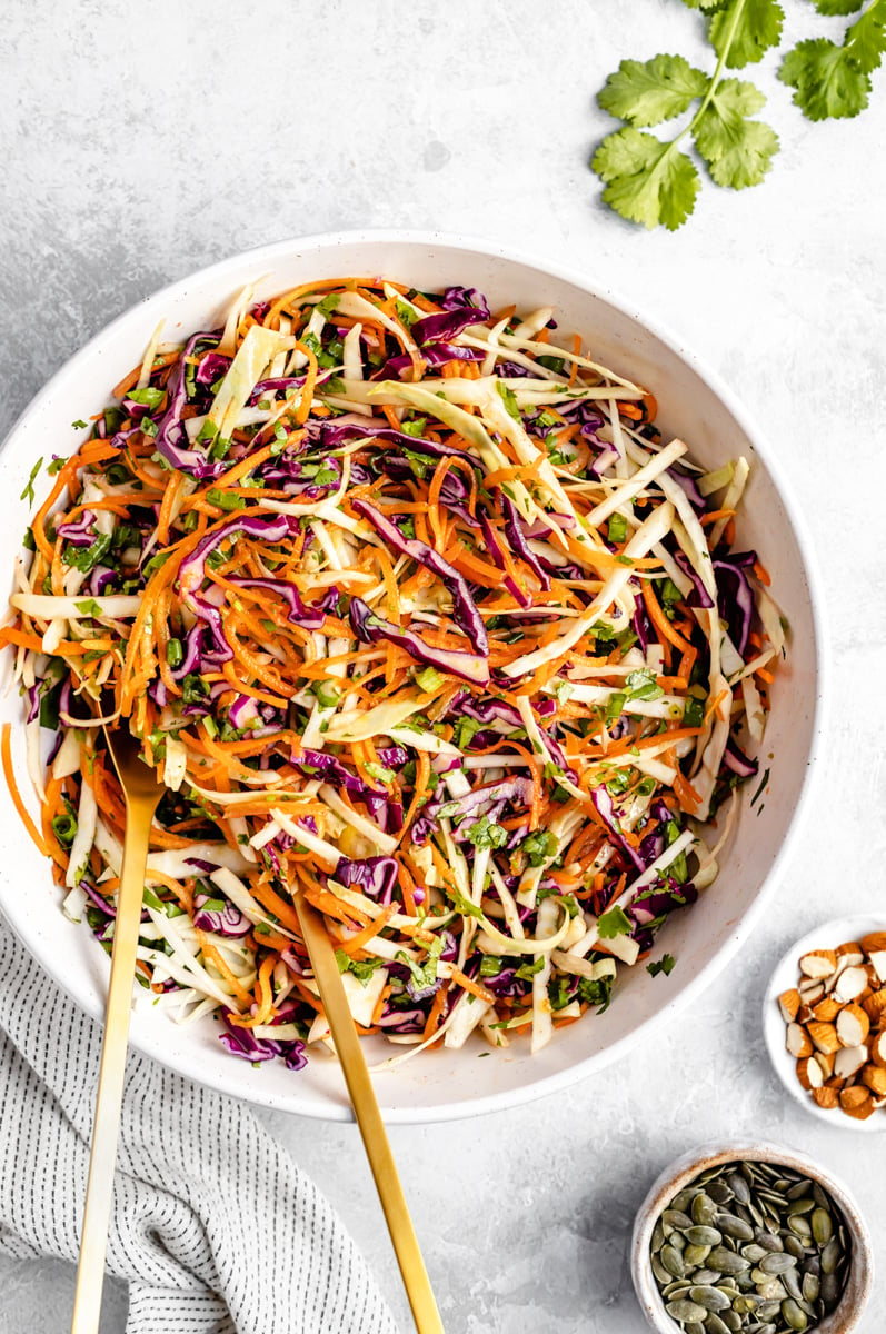 coleslaw in a bowl with two serving spoons