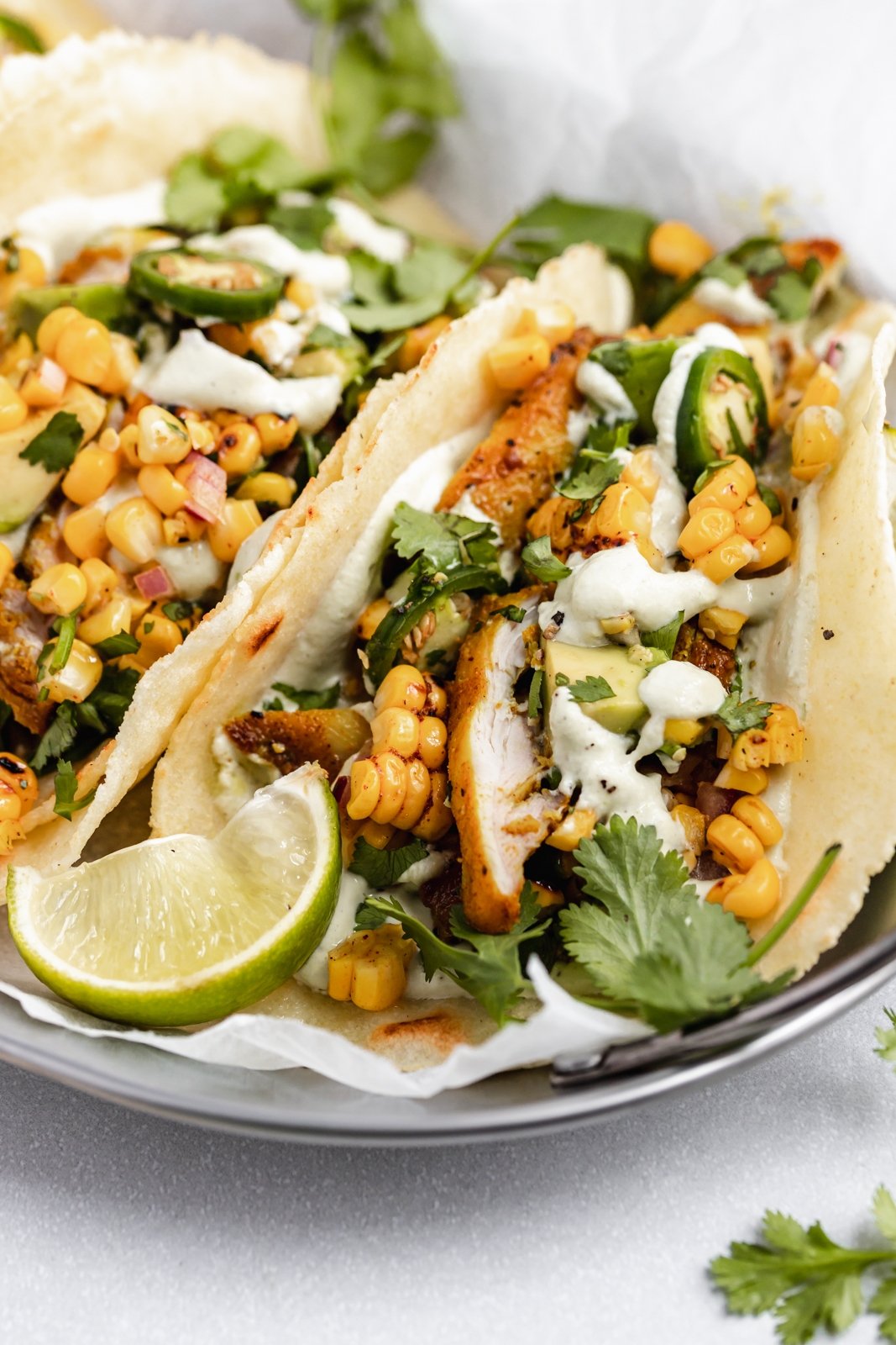 up close photo of street corn chicken tacos in a basket