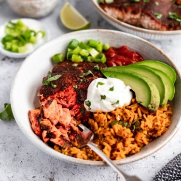 healthy salmon taco bowl topped with avocado and greek yogurt