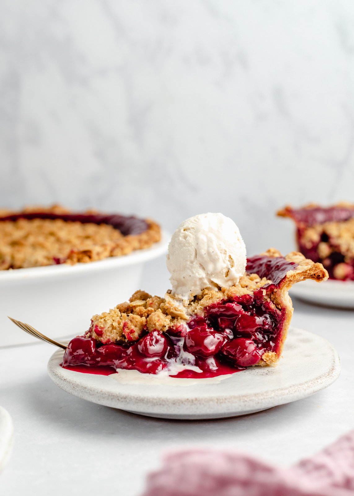 slice of dutch tart cherry pie on a plate with ice cream on top