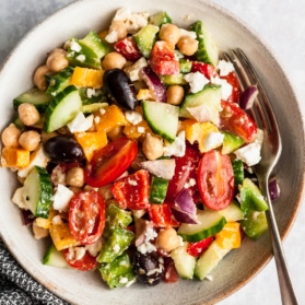 greek chickpea salad in a bowl with a fork