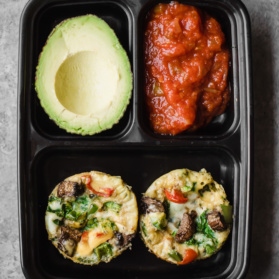 egg muffin cups in a container with avocado and salsa
