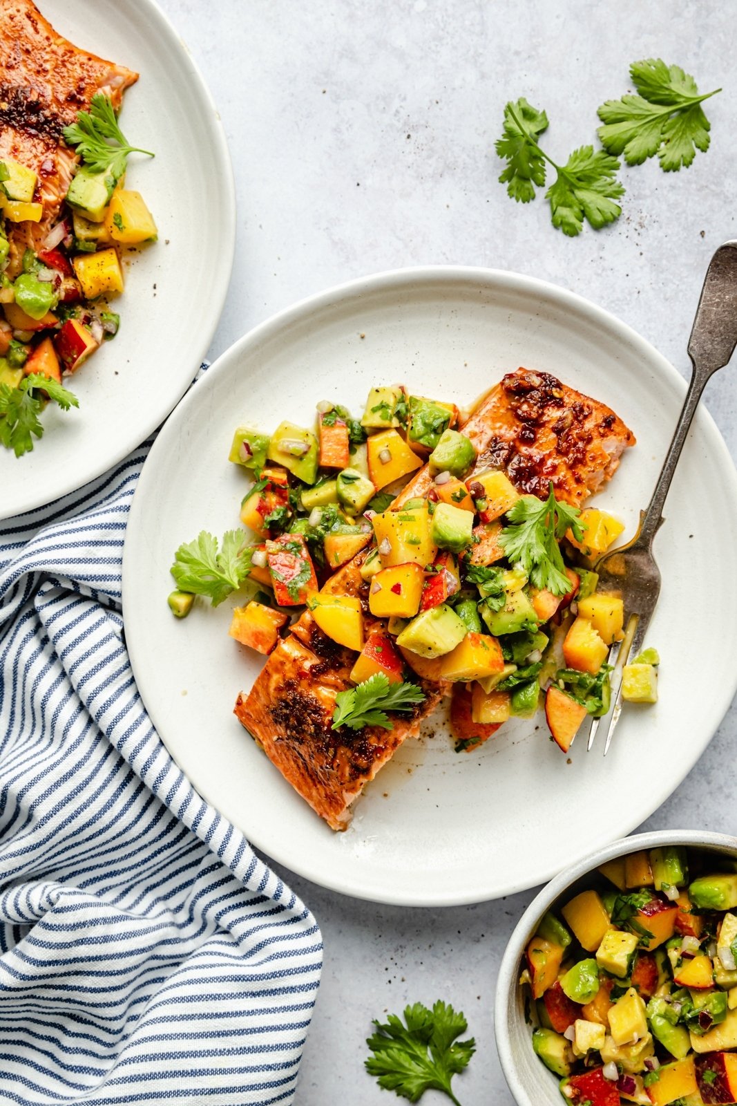 firecracker salmon on a plate topped with peach salsa