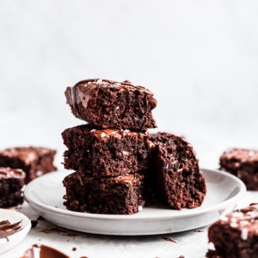 flourless almond butter brownies in a stack on a plate