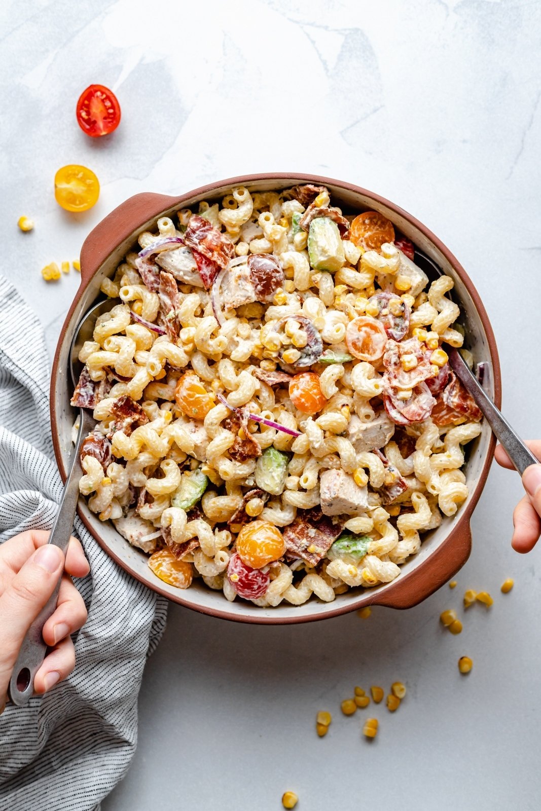 spooning up chicken and bacon pasta salad from a bowl