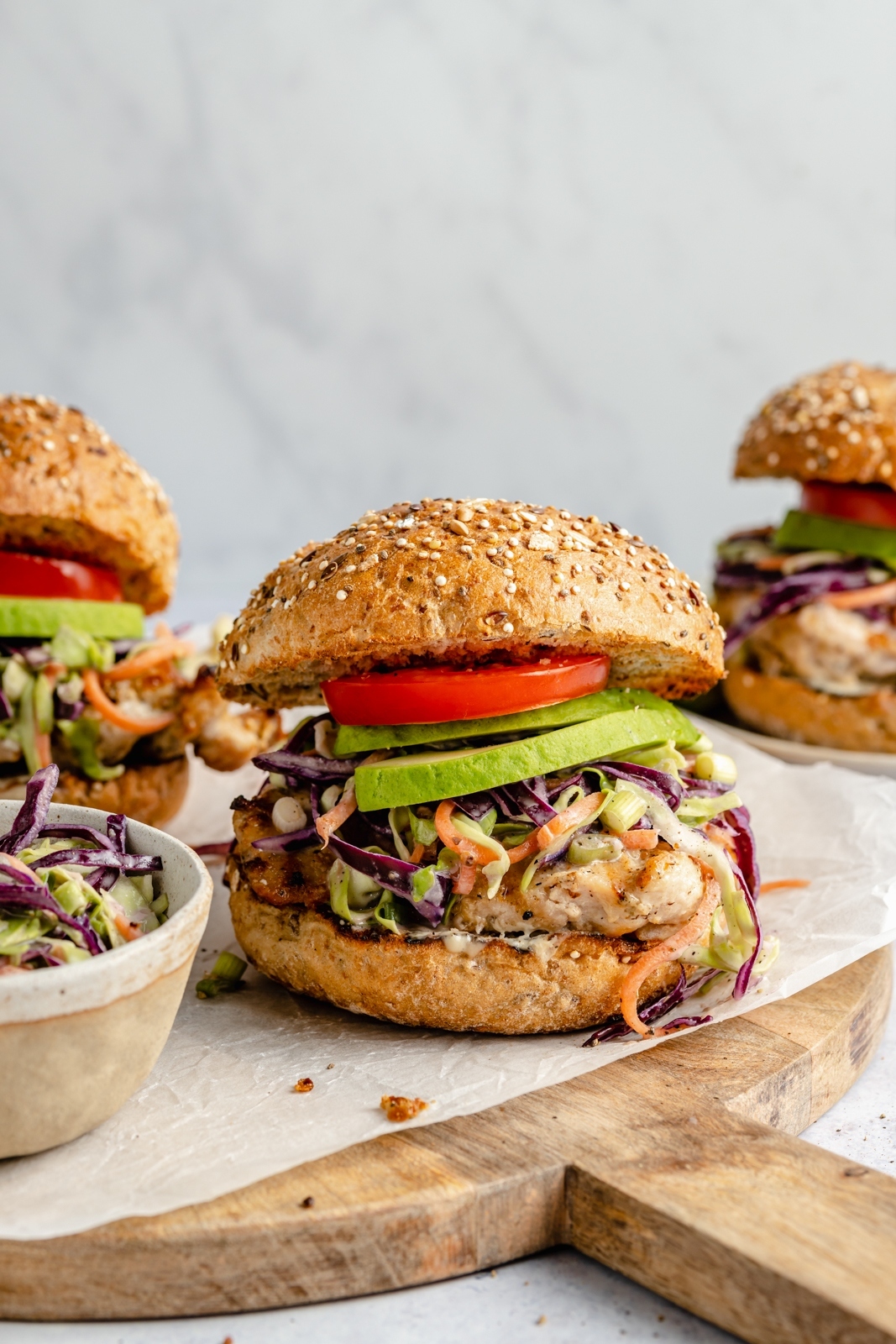 grilled chicken caesar sandwich with tahini slaw on a board