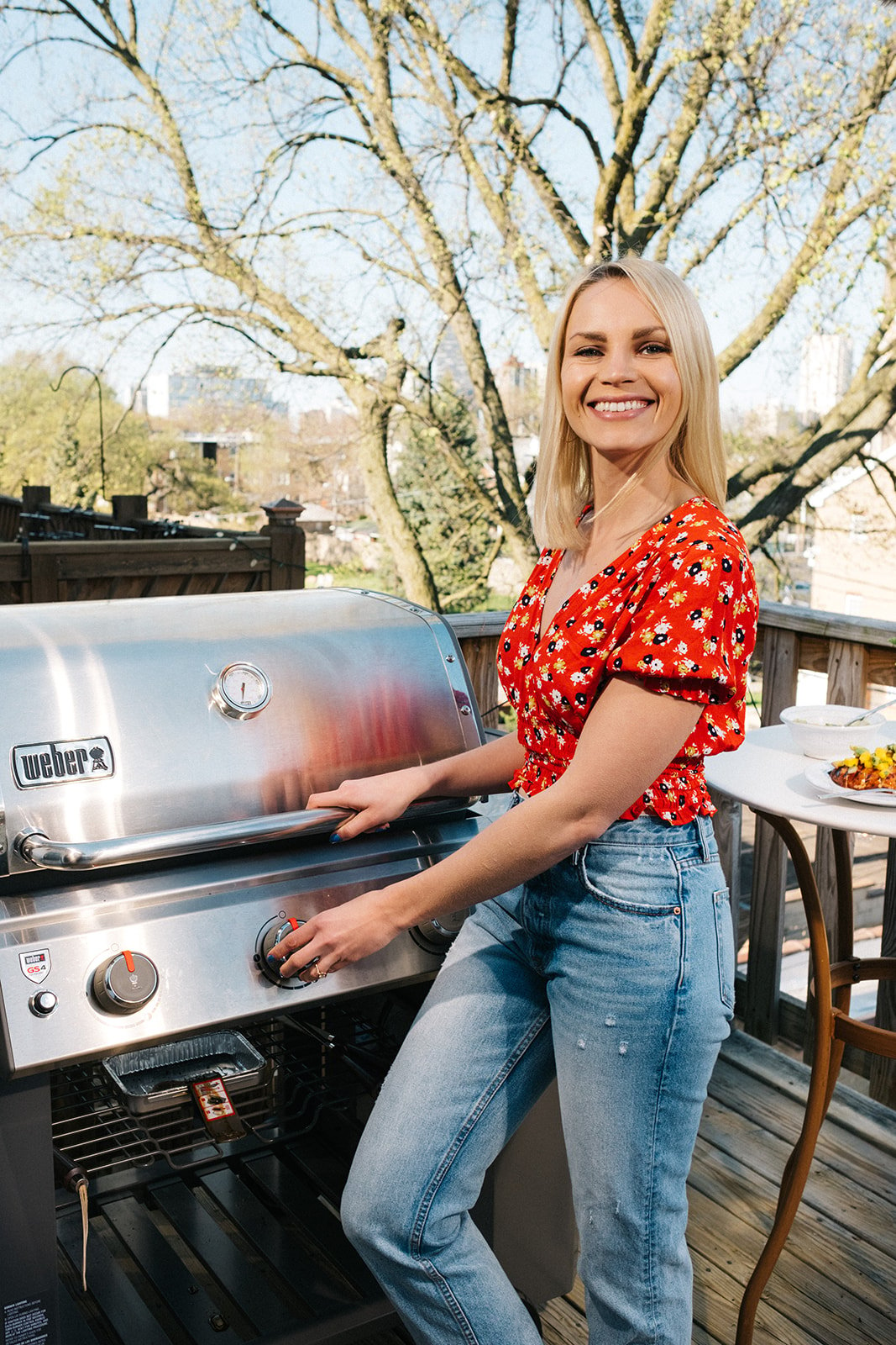 woman turning on a gas grill