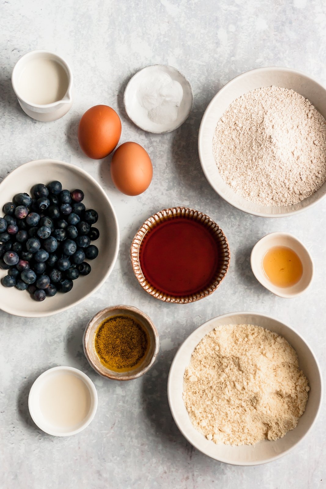 ingredients for healthy blueberry muffins on a grey board