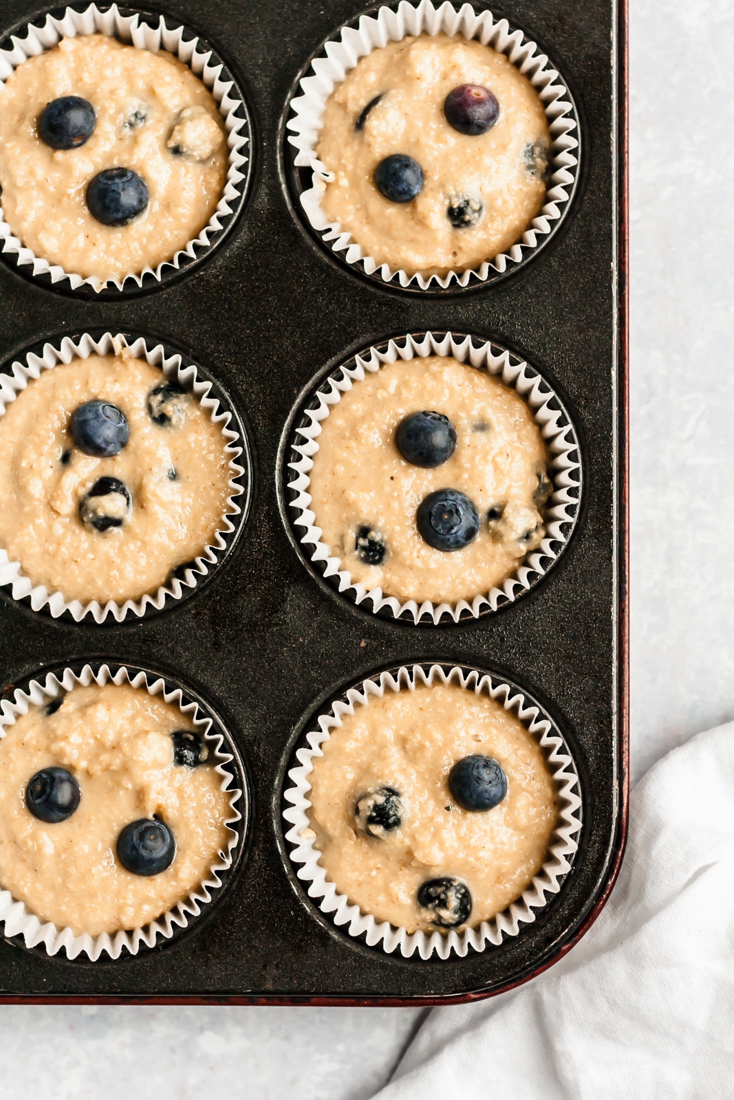 unbaked healthy blueberry muffins in a muffin tin with liners