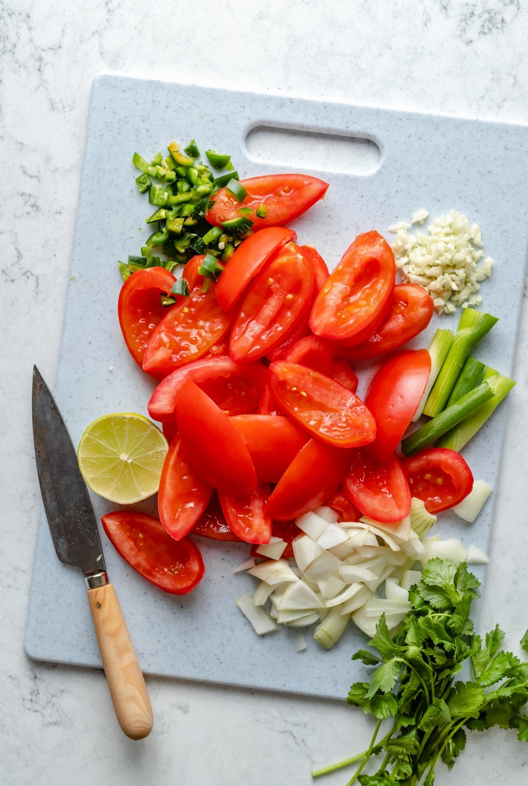 chopped ingredients on a cutting board to make tomato salsa