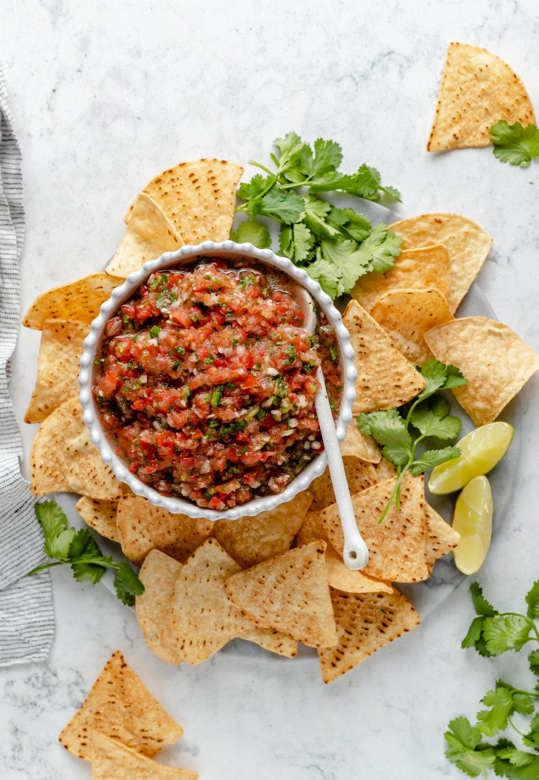 tomato salsa in a bowl surrounded by tortilla chips