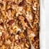 homemade chunky healthy granola on a baking sheet with a spoon