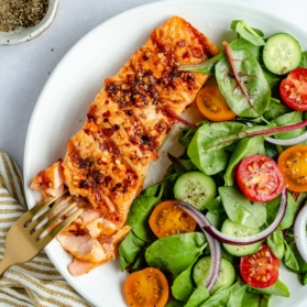 grilled salmon on a plate with a salad