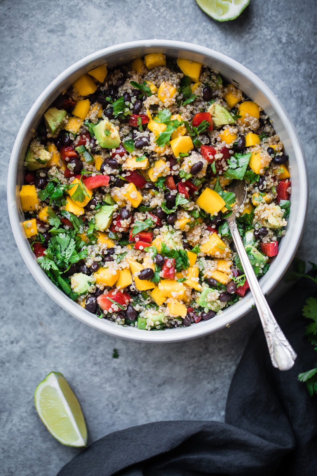 healthy mango quinoa salad in a bowl with a spoon