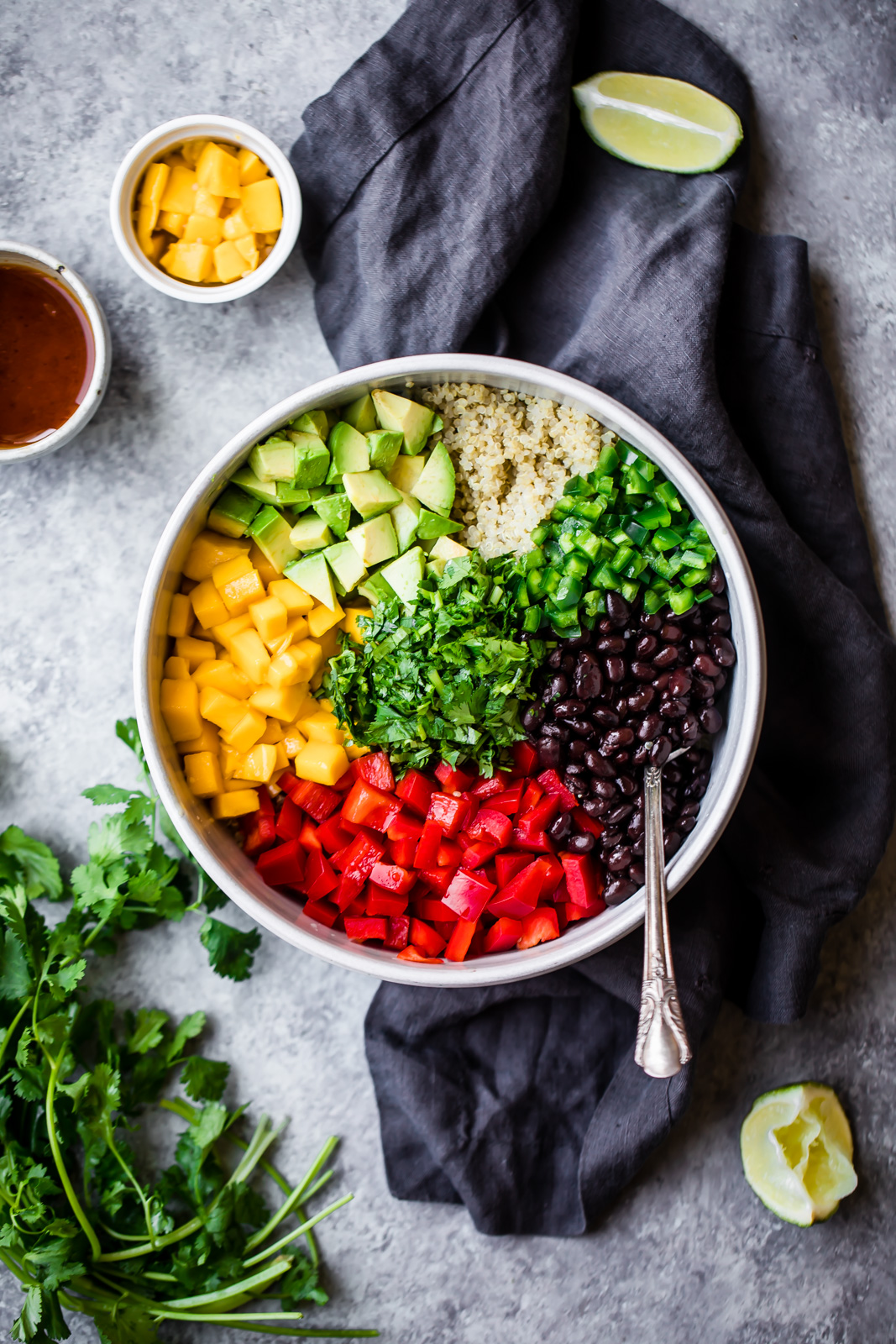 healthy mango black bean quinoa salad in a bowl on top of a linen