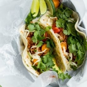 slow cooker turkey tacos in a container with parchment paper