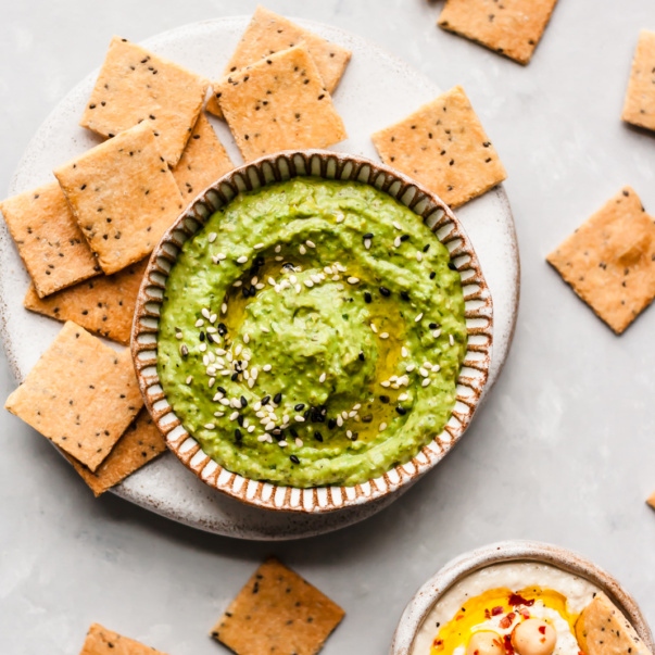 paleo crackers on a plate next to a bowl of guacamole