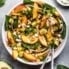 peach spinach salad with avocado and feta in a bowl