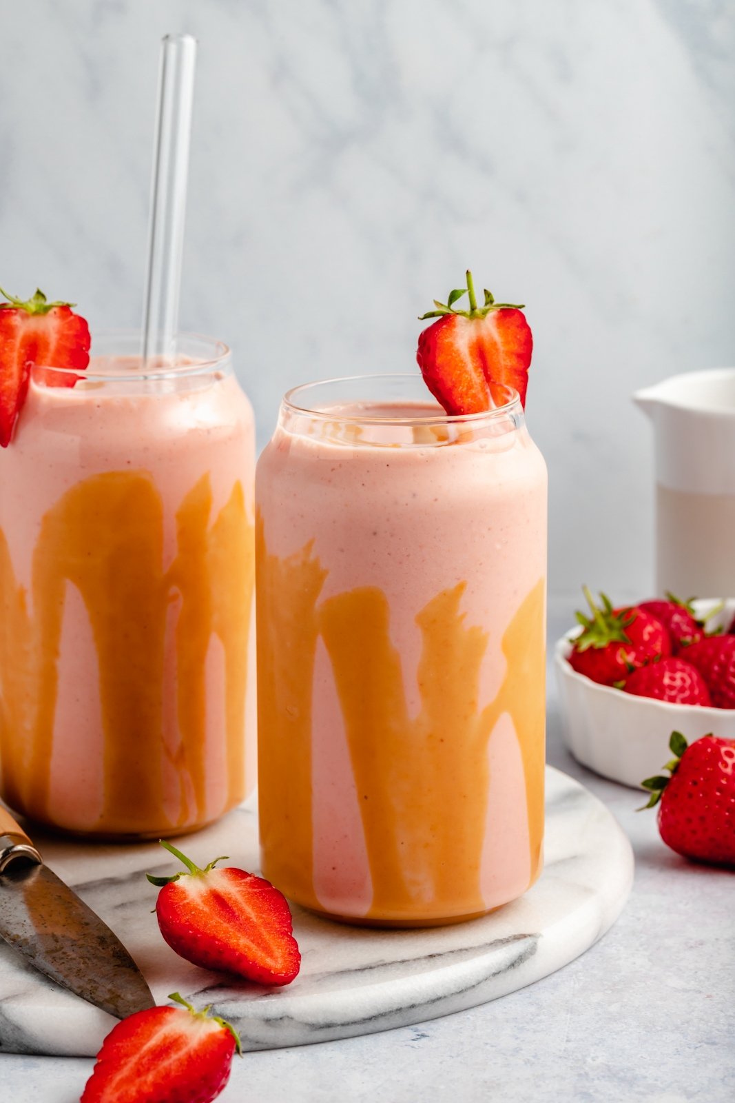 two strawberry banana peanut butter smoothies in glasses