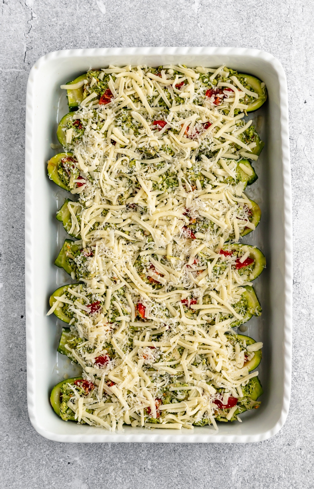 easy pesto chicken zucchini boats unbaked in a baking dish