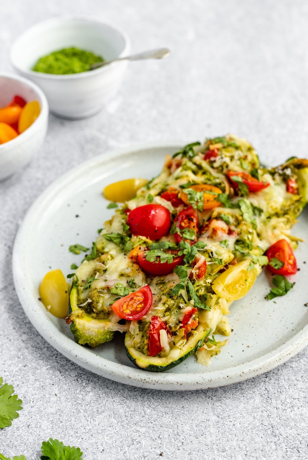 two healthy pesto chicken zucchini boats on a plate