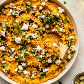 healthy carrot dip in a bowl with herbs and feta