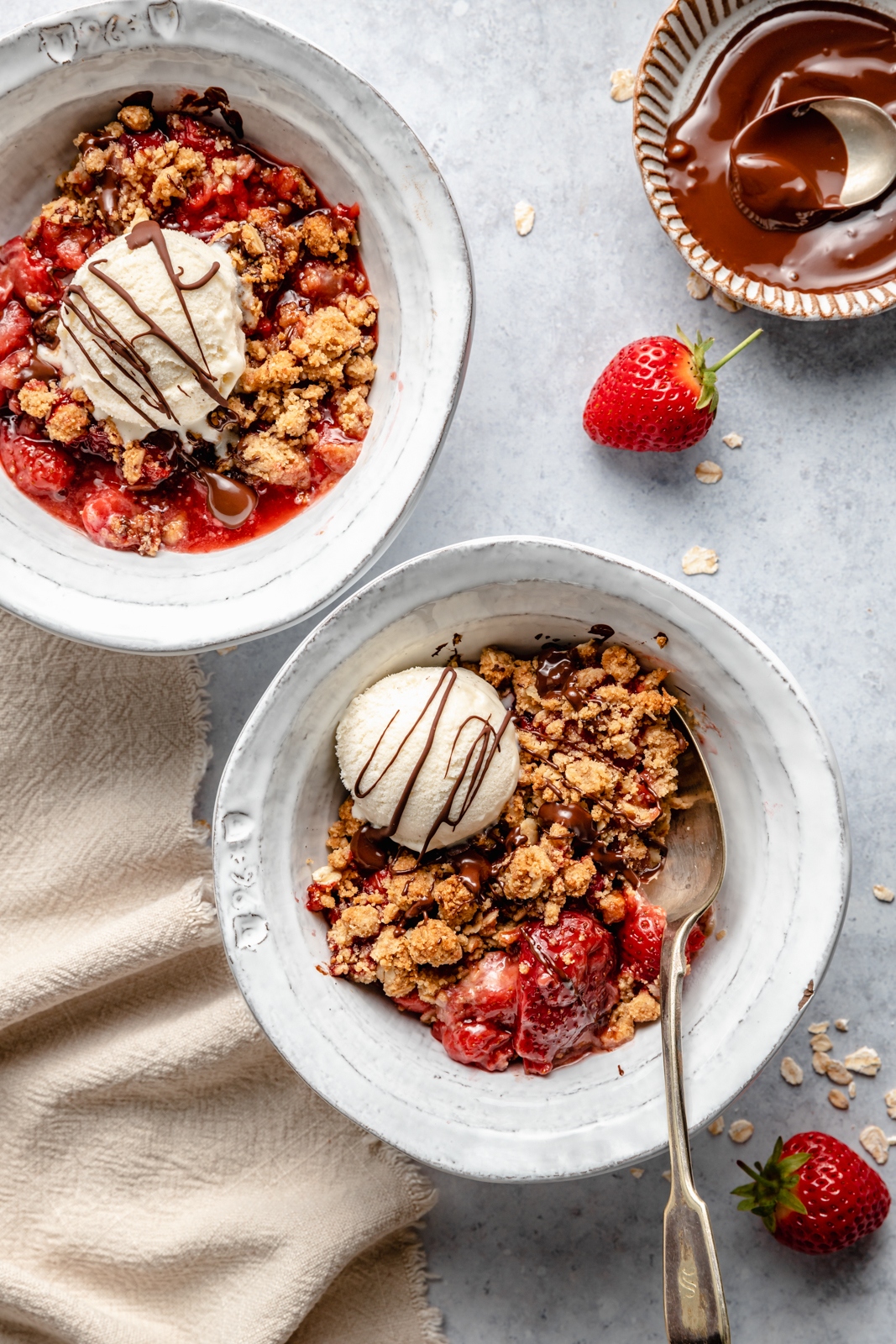 strawberry crisp in two bowls with ice cream