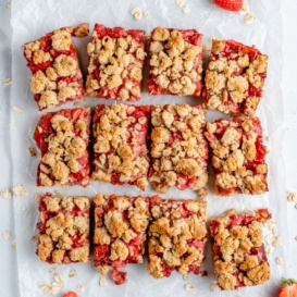 strawberry crumble bars sliced on parchment paper