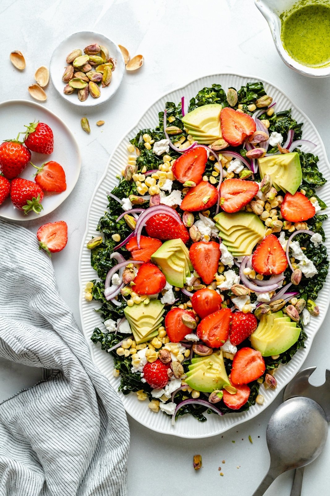 chopped kale salad with strawberries and avocado on a platter