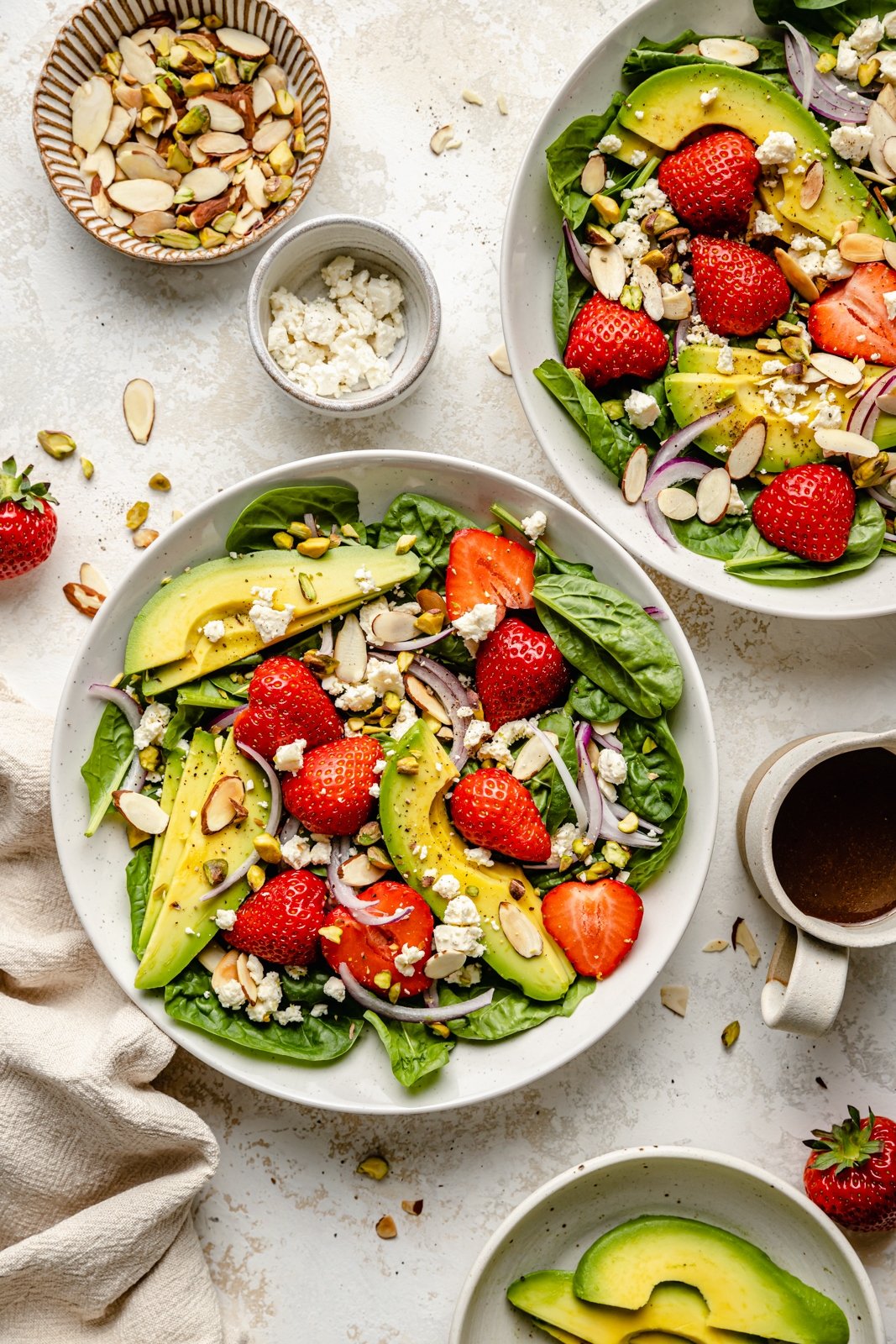 easy strawberry spinach salad in bowls next to ingredients