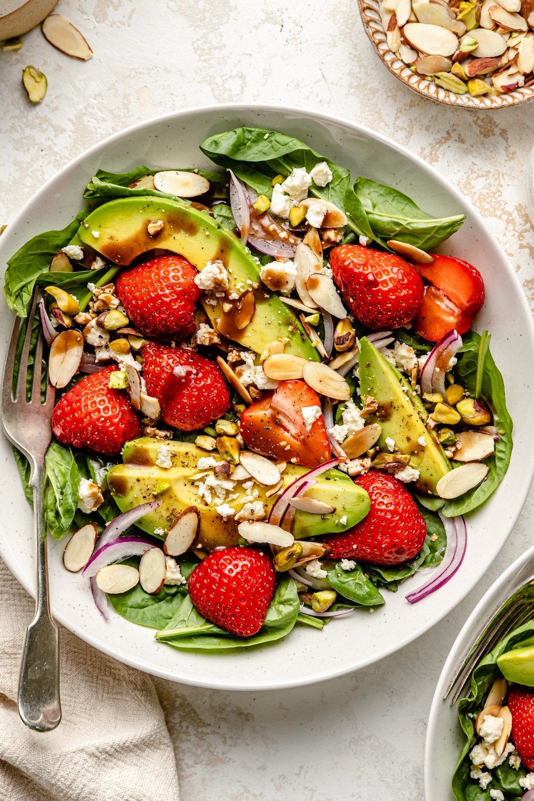 strawberry spinach salad in a bowl with a fork
