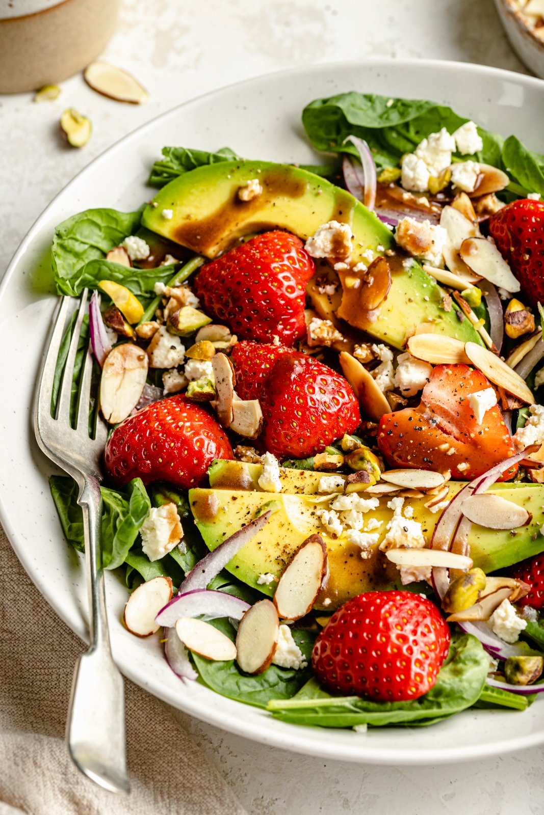 healthy strawberry spinach salad in a bowl with a fork