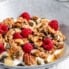 nut and seed granola in a bowl with yogurt and raspberries