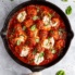 turkey meatballs in a skillet with tomato basil sauce and burrata
