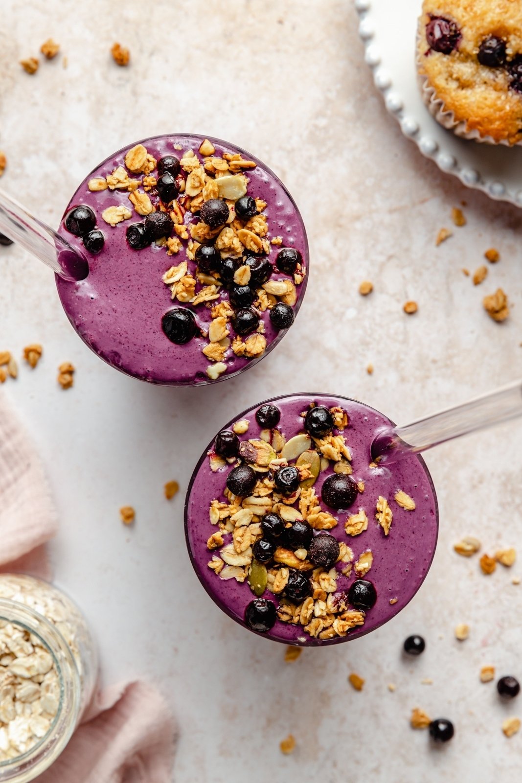 top-down view of two blueberry smoothies topped with oats